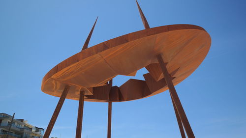 Low angle view of windmill against clear blue sky