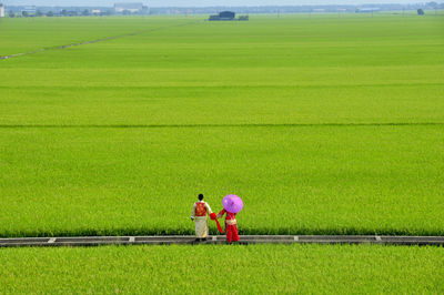 Rear view of couple standing on field