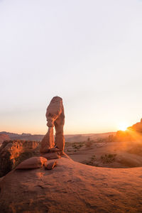 Rock formations in desert against sky during sunset