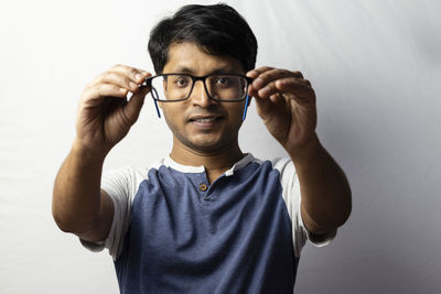 Portrait of young man standing against white background