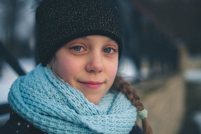 Close-up portrait of smiling girl in snow