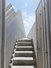 Low angle view of staircase amidst buildings against sky