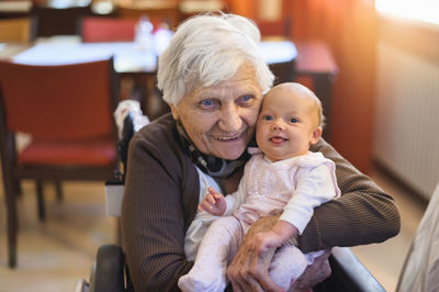 Old woman meeting her great granddaughter