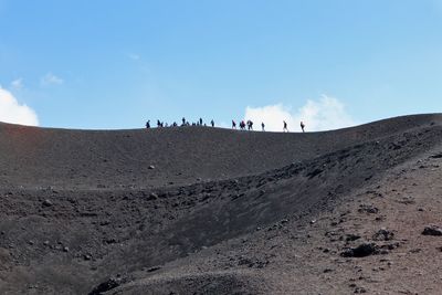 Group of people on land against sky