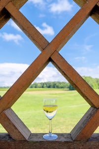 Close-up of wine glass on table against sky