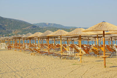 Chairs on beach against clear sky