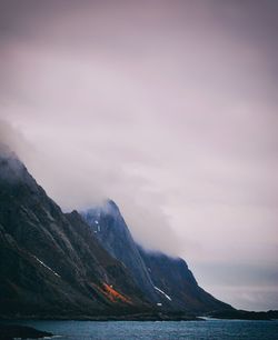 Scenic view of sea and mountains against sky