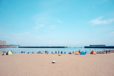 Group of people on beach against sky