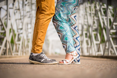 Low section of couple standing on road