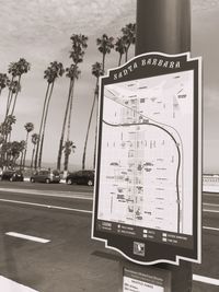 Close-up of information sign on table against trees