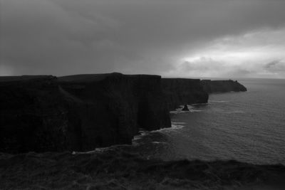 Rock formations by sea against sky