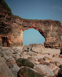 Rock formation amidst sea against clear sky