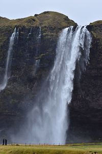 Scenic view of waterfall against sky