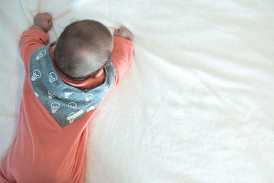 High angle view of child lying on bed