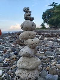 Stack of stones on beach against sky