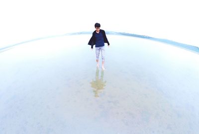 Full length of a young woman standing in water