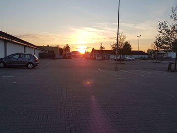 Cars on road against sky during sunset