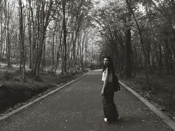 Woman standing amidst trees in forest