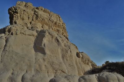 Low angle view of rock formation against sky