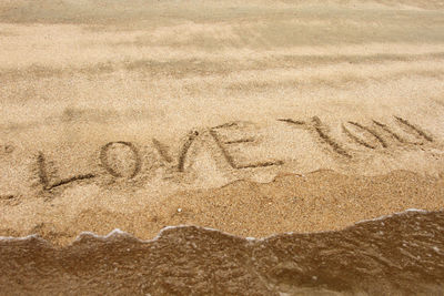 High angle view of text on sand at beach