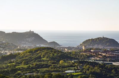 High angle view of townscape by sea against clear sky