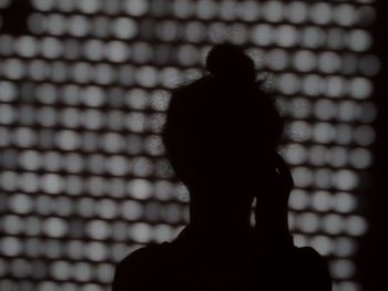 Rear view of silhouette woman against blurred background