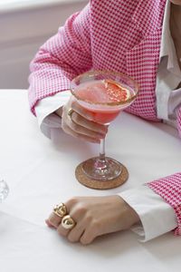 High angle view of woman holding coctail cup on table