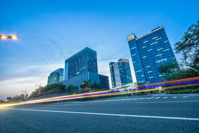 View of city street and modern buildings against sky