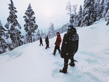 People walking on snow covered landscape