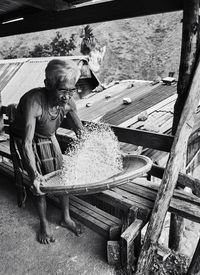Man working on stack of wood