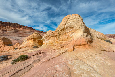 Scenic view of rock formations against cloudy sky