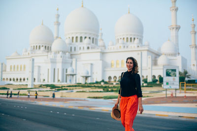 Portrait of woman walking against tag mahal in city