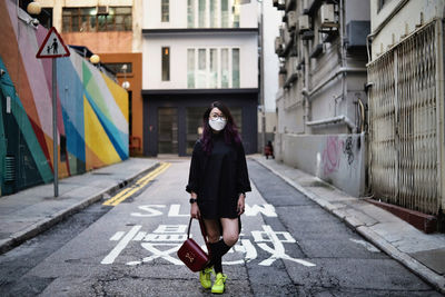 Full length portrait of woman on street in city