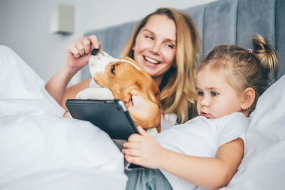 Portrait of young woman with dog at home