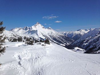 Scenic view of snowcapped mountains against blue sky