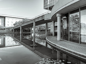 Bridge by swimming pool against buildings in city