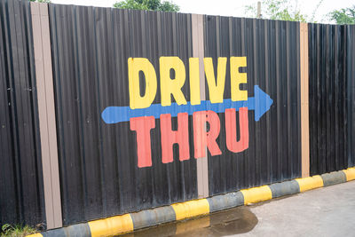 Close-up of yellow sign hanging on wall