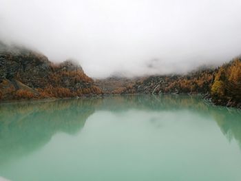 Scenic view of lake by mountains against sky