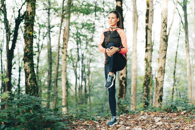 Full length of woman standing in forest