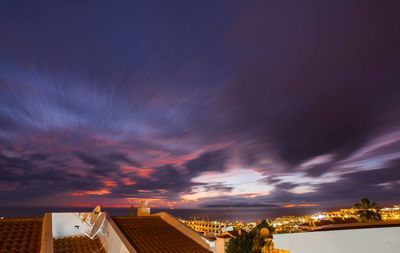 Low angle view of illuminated buildings against sky at sunset