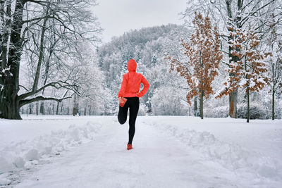 Running woman, girl runner on snow in park winter day. run, sport concept, leisure and freedom.