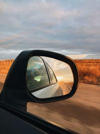 Reflection of road on side-view mirror during sunset