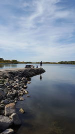 Men fishing on pier at lake