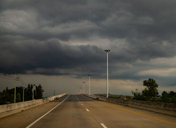 Empty road against cloudy sky