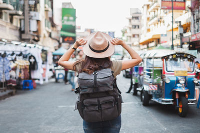 Rear view of woman standing on street in city