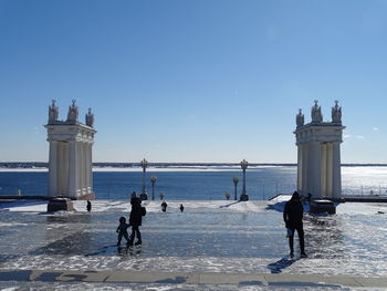 People at beach against sky