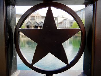 Close-up of old wheel seen through window