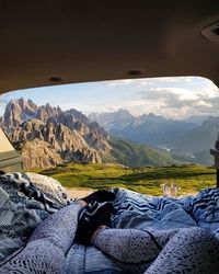 Man relaxing on snowcapped mountains against sky