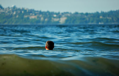 Boy swimming in lake