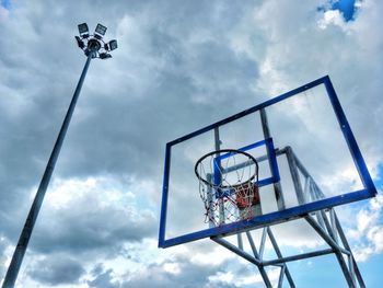 Low angle view of basketball hoop against cloudy sky